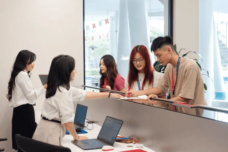 BUV students receive support at the International Office reception desk with staff and laptops