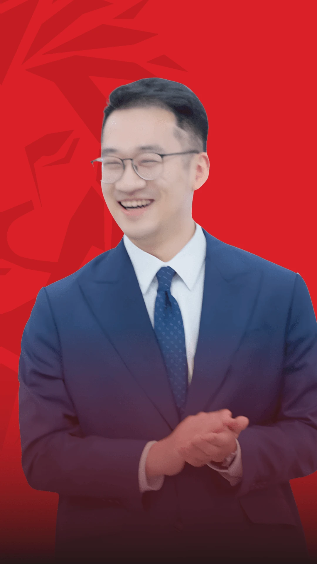 Portrait of a smiling BUV alumnus in a blue suit and tie, standing against a red background.
