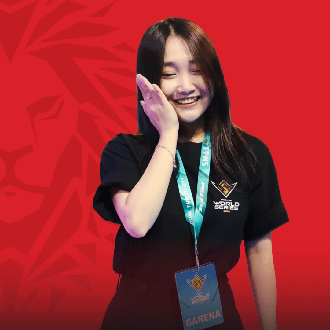 Smiling BUV alumna wearing a World Series T-shirt and Garena event pass against a red background.