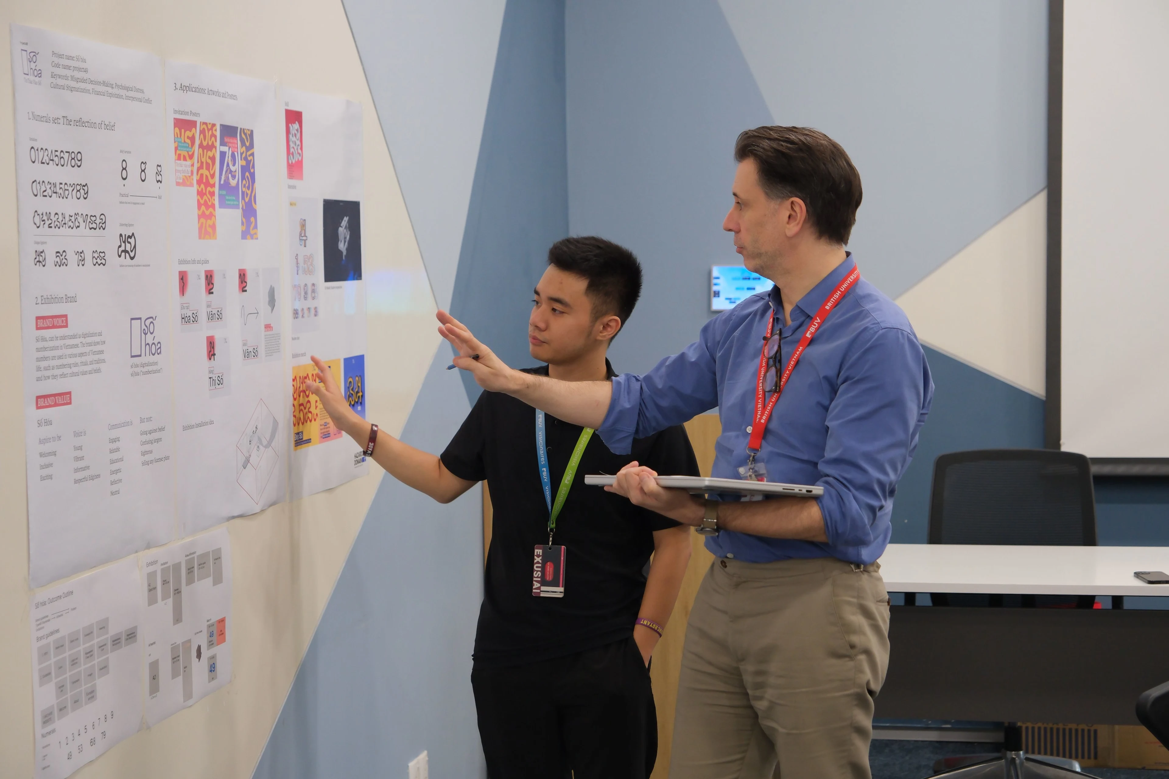 British University Vietnam lecturer and student review a graphic design project during a classroom critique.