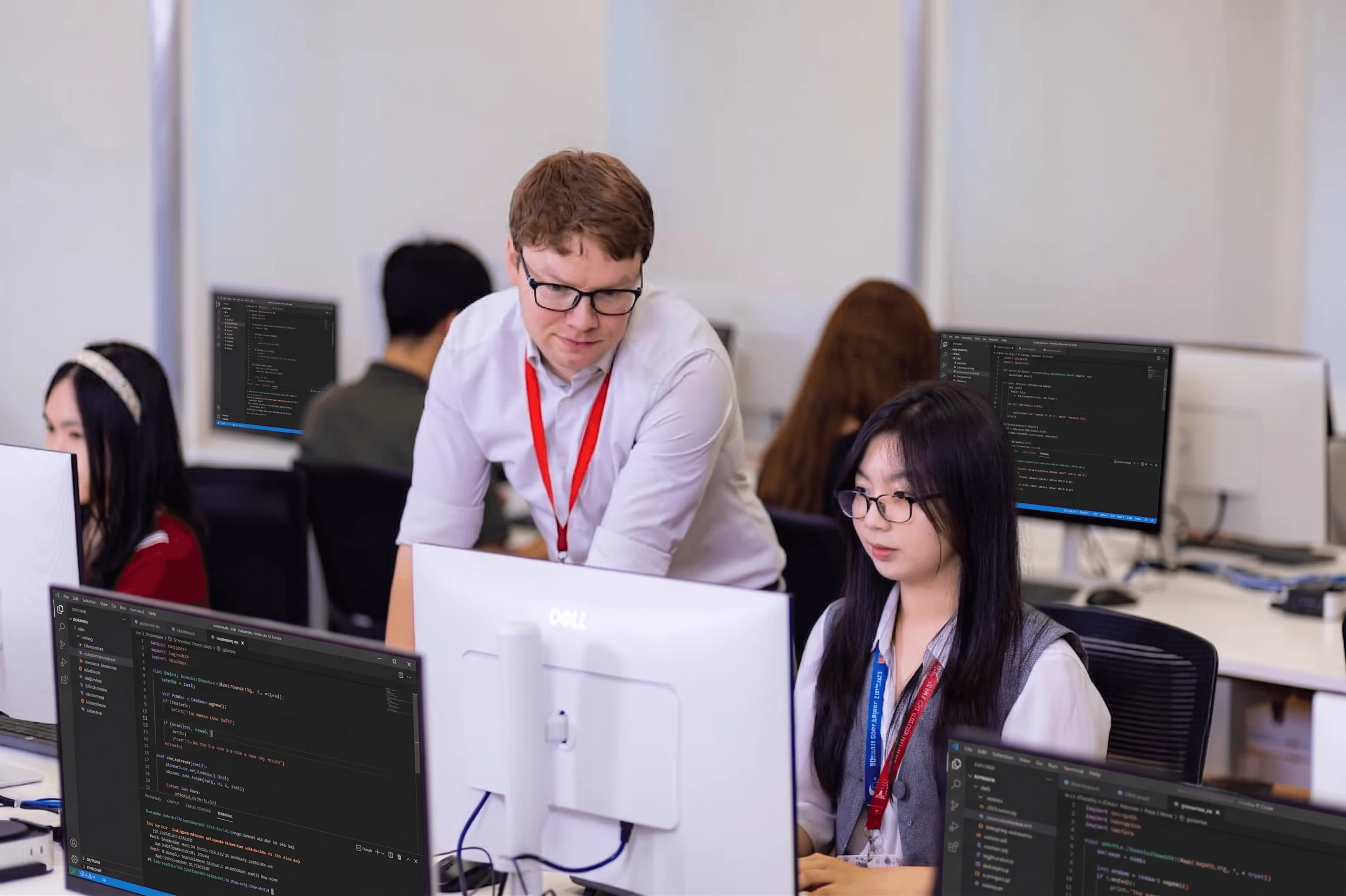 BUV lecturer guides a student through coding in a modern computer lab.