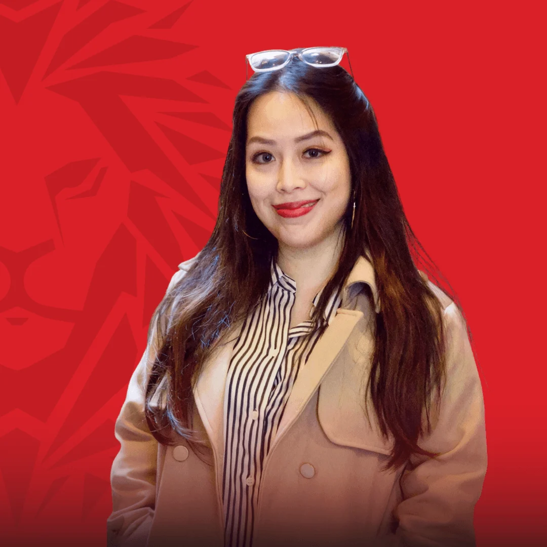 Chân dung nữ cựu sinh viên BUV trong trang phục công sở trên nền đỏ thương hiệu.