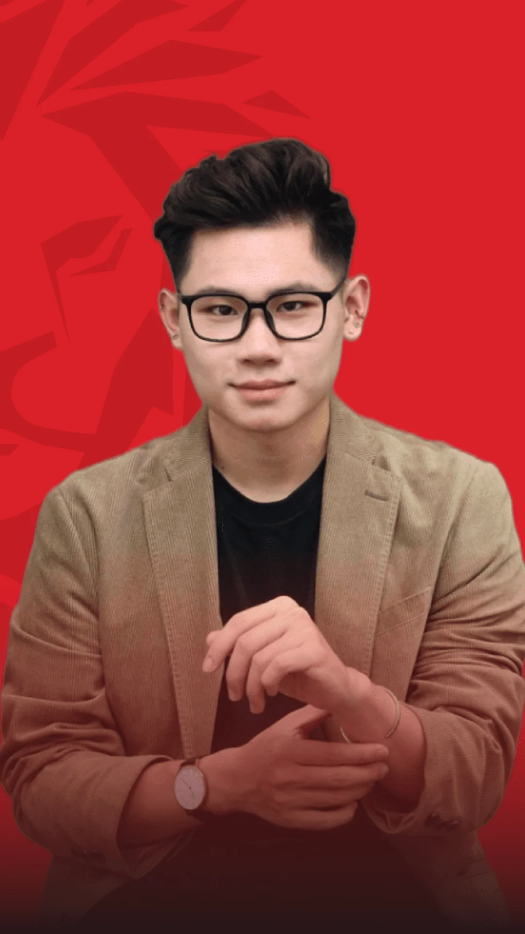 Nam cựu sinh viên BUV đeo kính, mặc blazer nâu trên nền đỏ thương hiệu British University Vietnam