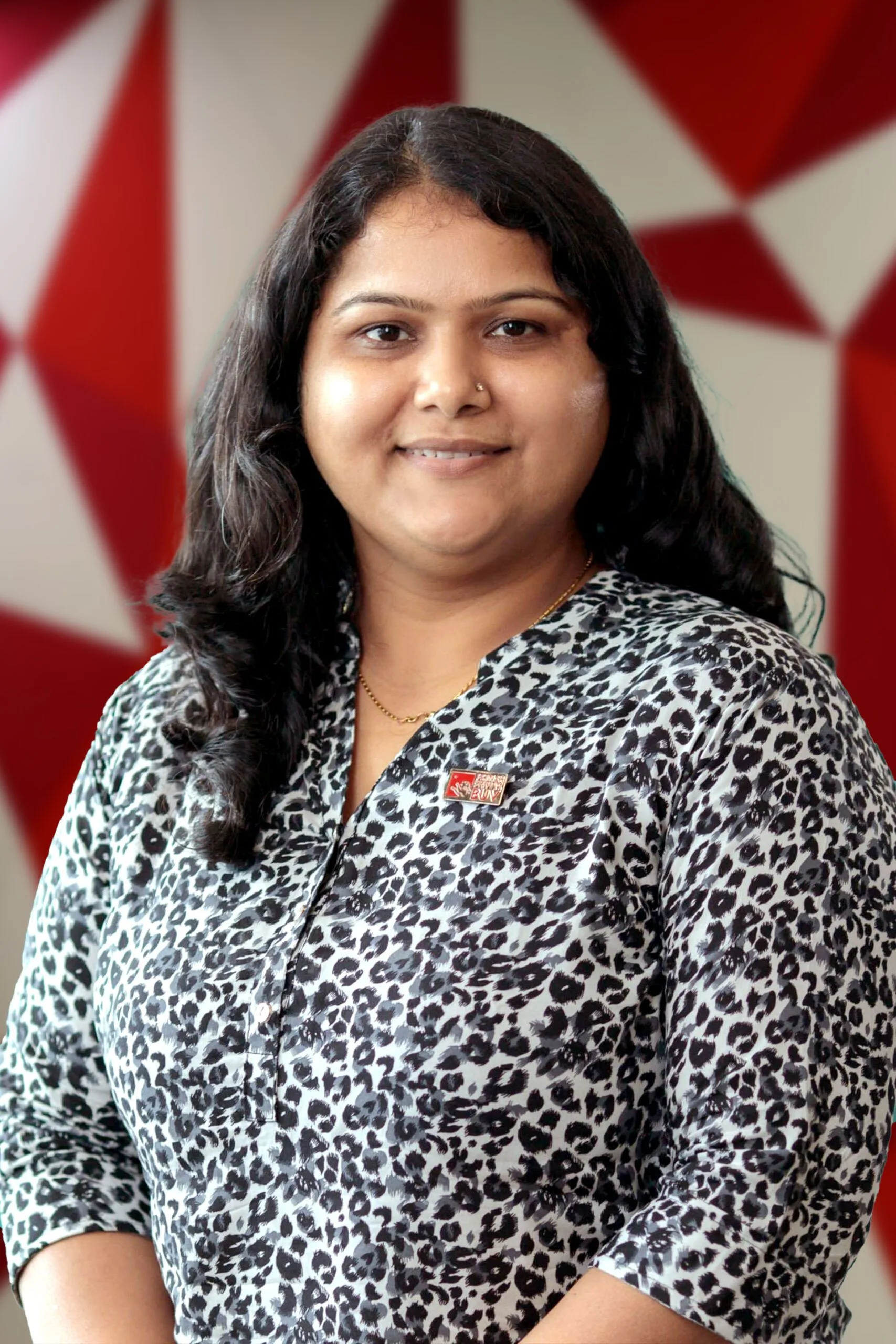 Professional portrait of Dr Jyotsna Bijalwan against a red-and-white geometric background
