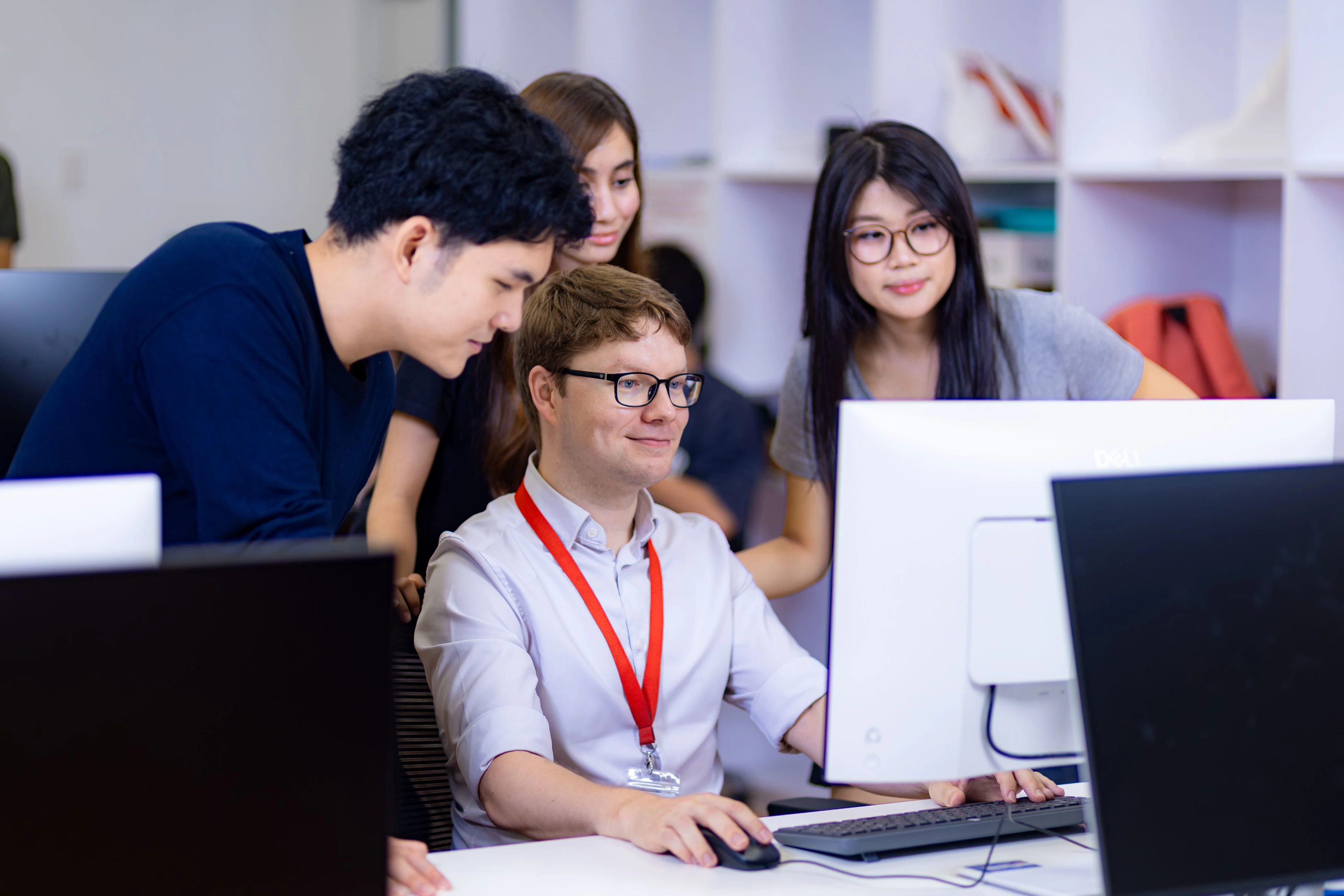 Giảng viên hướng dẫn sinh viên BUV học nhóm trên máy tính tại phòng thực hành công nghệ