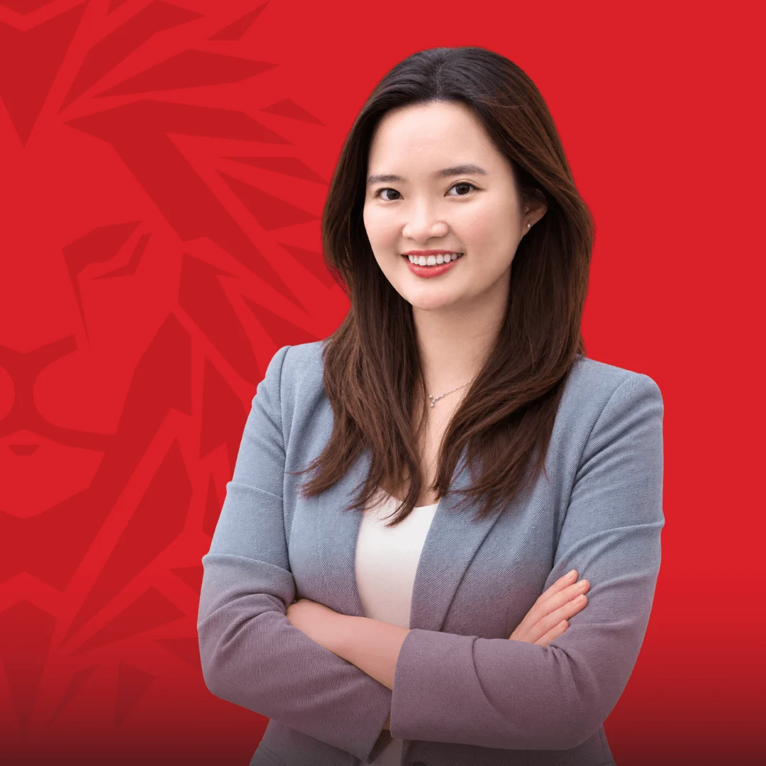 Chân dung nữ cựu sinh viên BUV mặc blazer xám trên nền đỏ mang họa tiết Union Jack