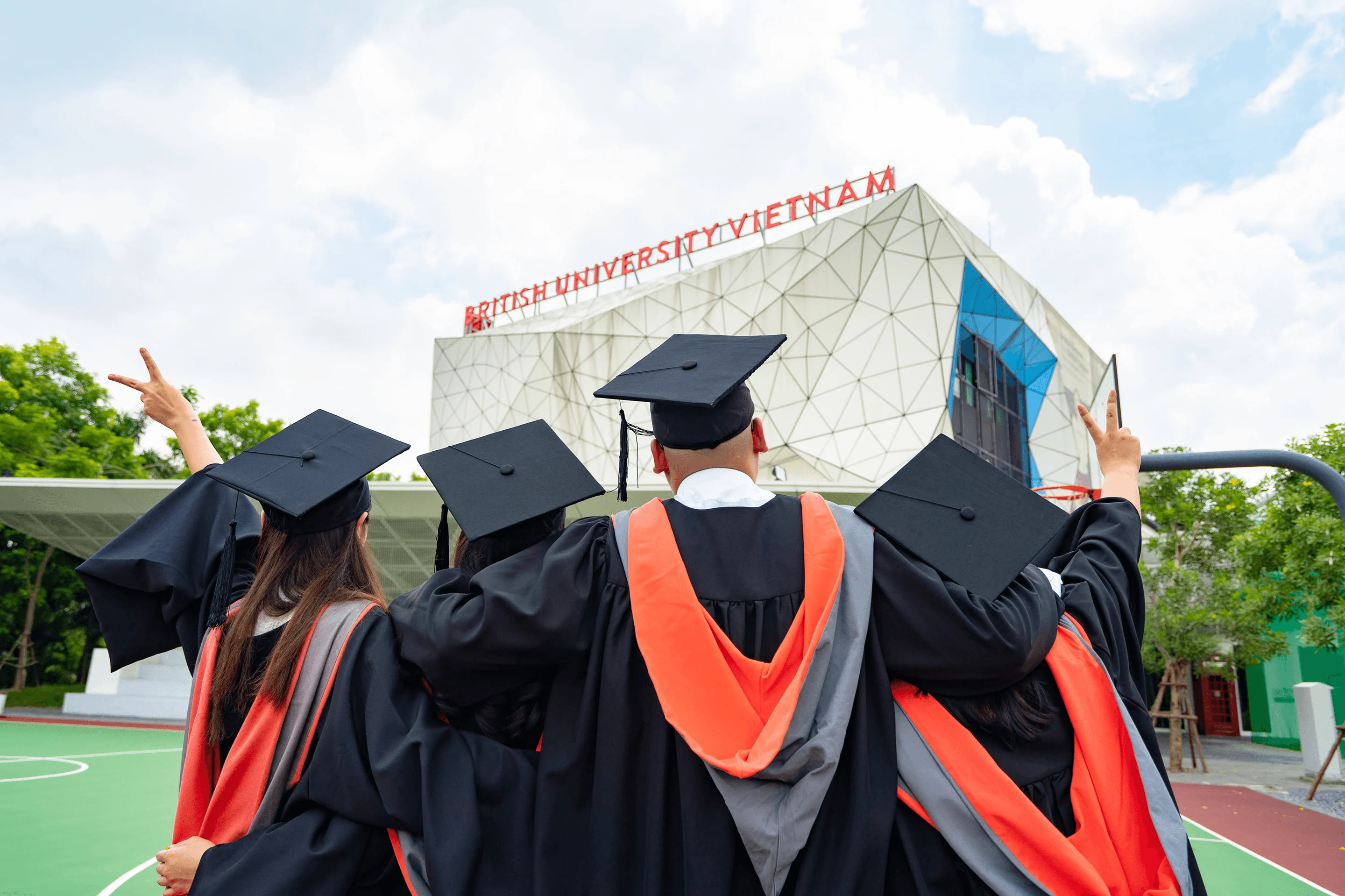 Graduates in caps and gowns outside British University Vietnam.