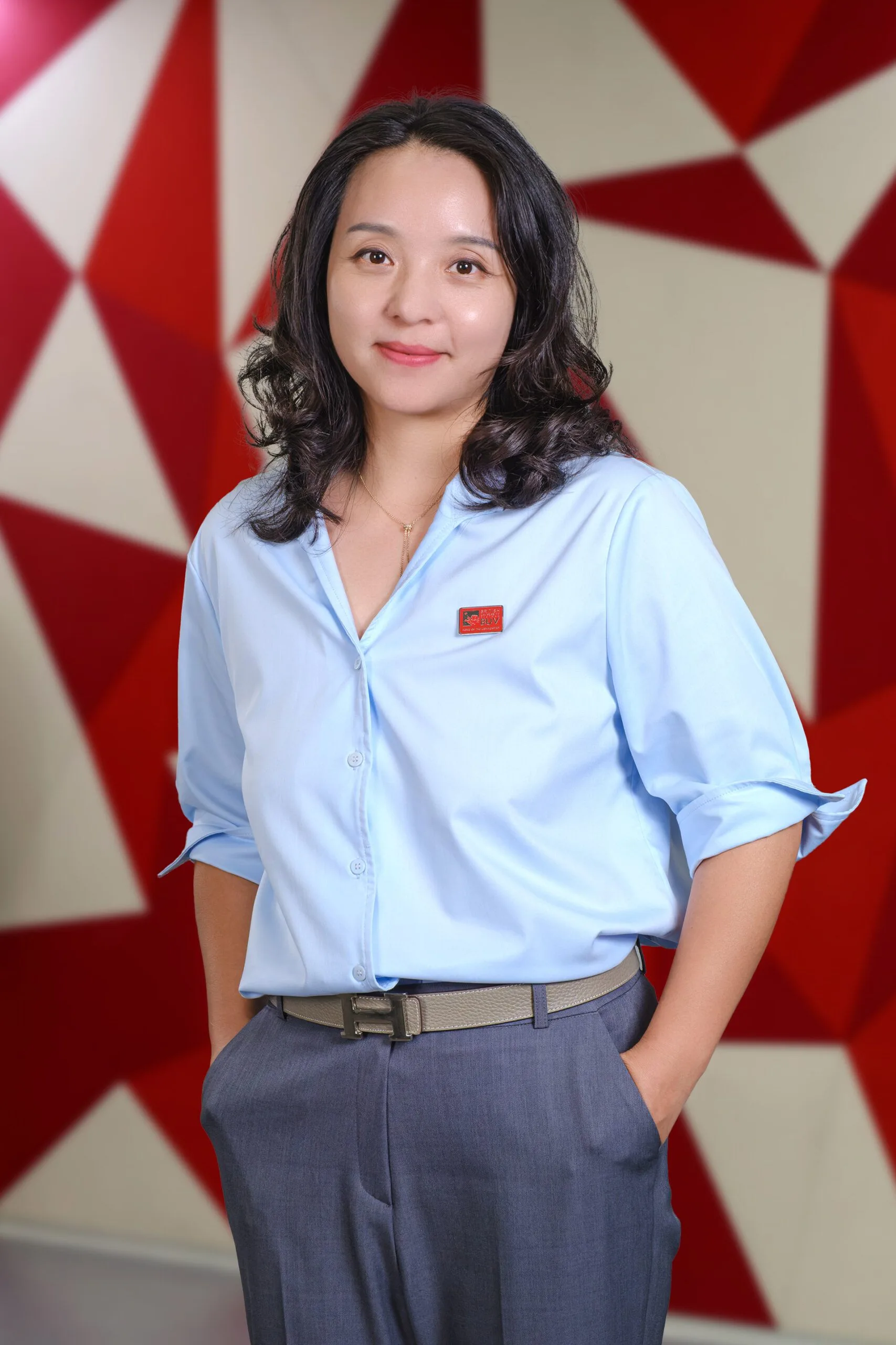 Dr Chong Zeng, British University Vietnam faculty member, wearing a light blue shirt with BUV badge