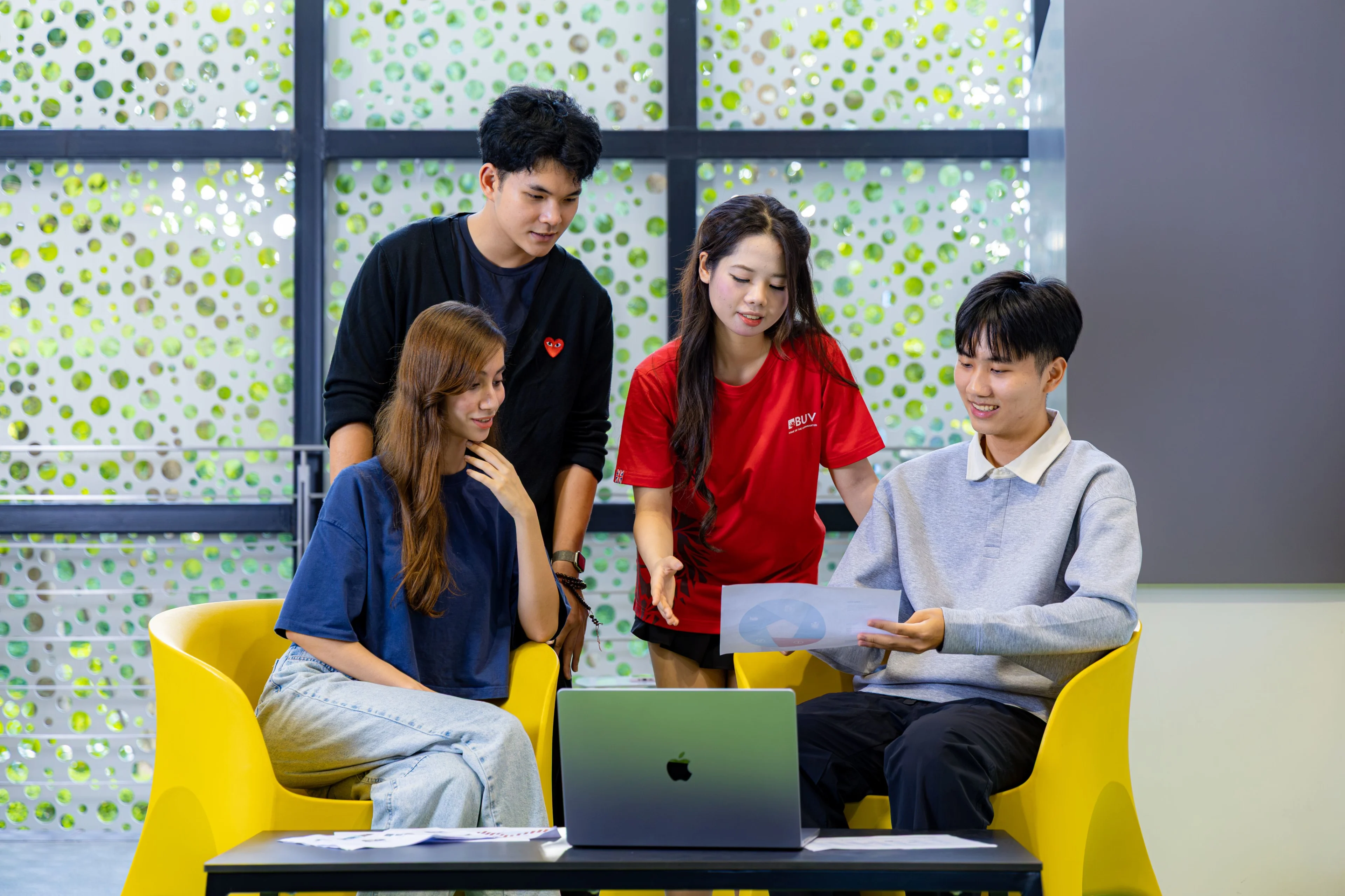 Sinh viên BUV thảo luận dự án nhóm bên laptop trong không gian học tập hiện đại tại British University Vietnam