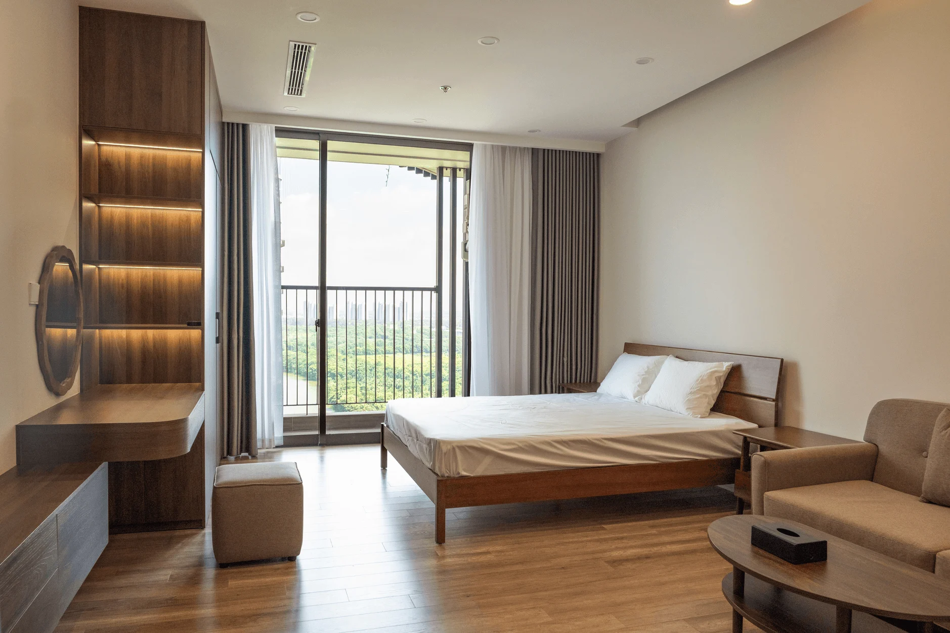 Modern BUV student accommodation bedroom with balcony, study desk, lounge chair and scenic city view