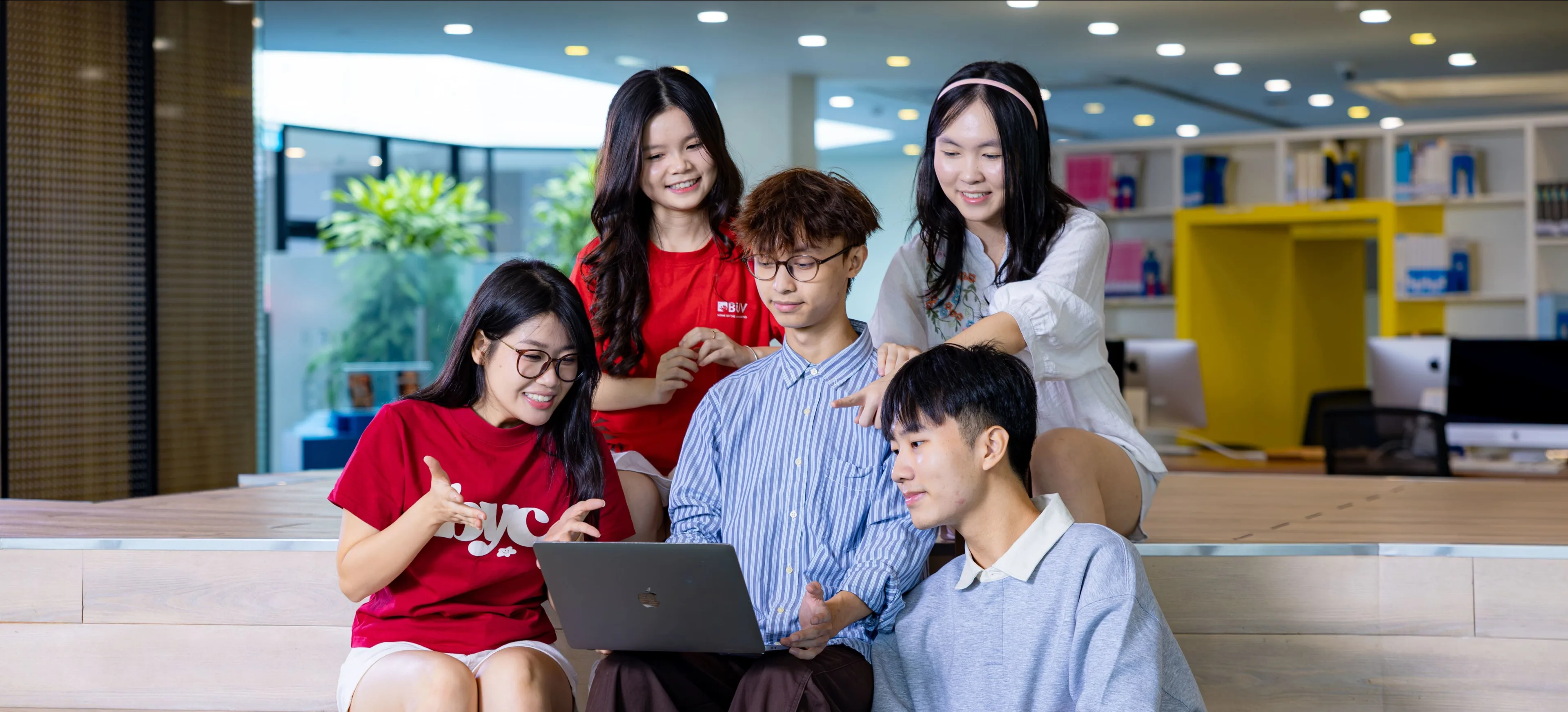 Sinh viên BUV học nhóm với laptop trong khuôn viên đại học hiện đại.