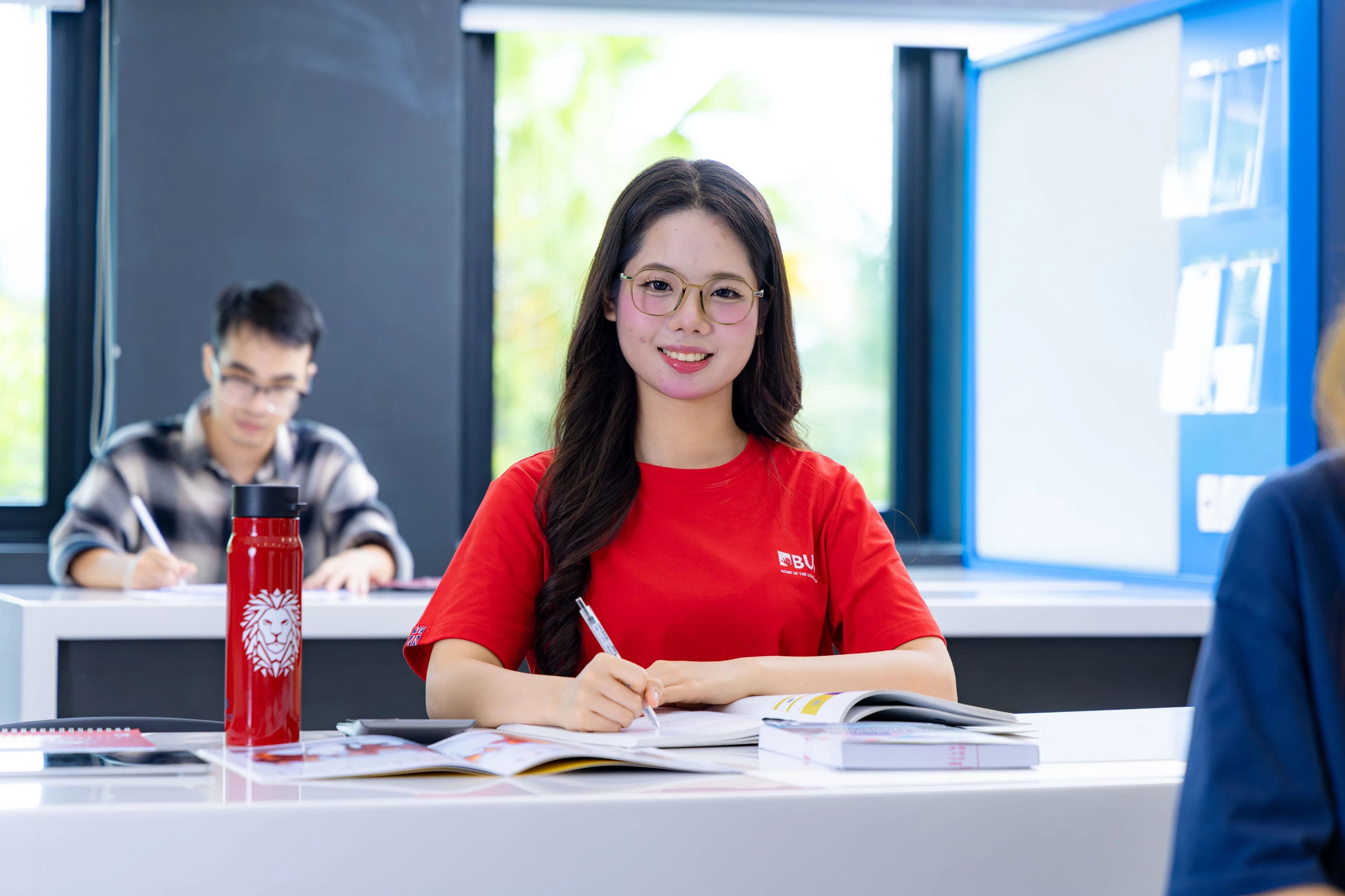 Sinh viên BUV mặc áo đỏ học tập trong lớp học hiện đại tại British University Vietnam