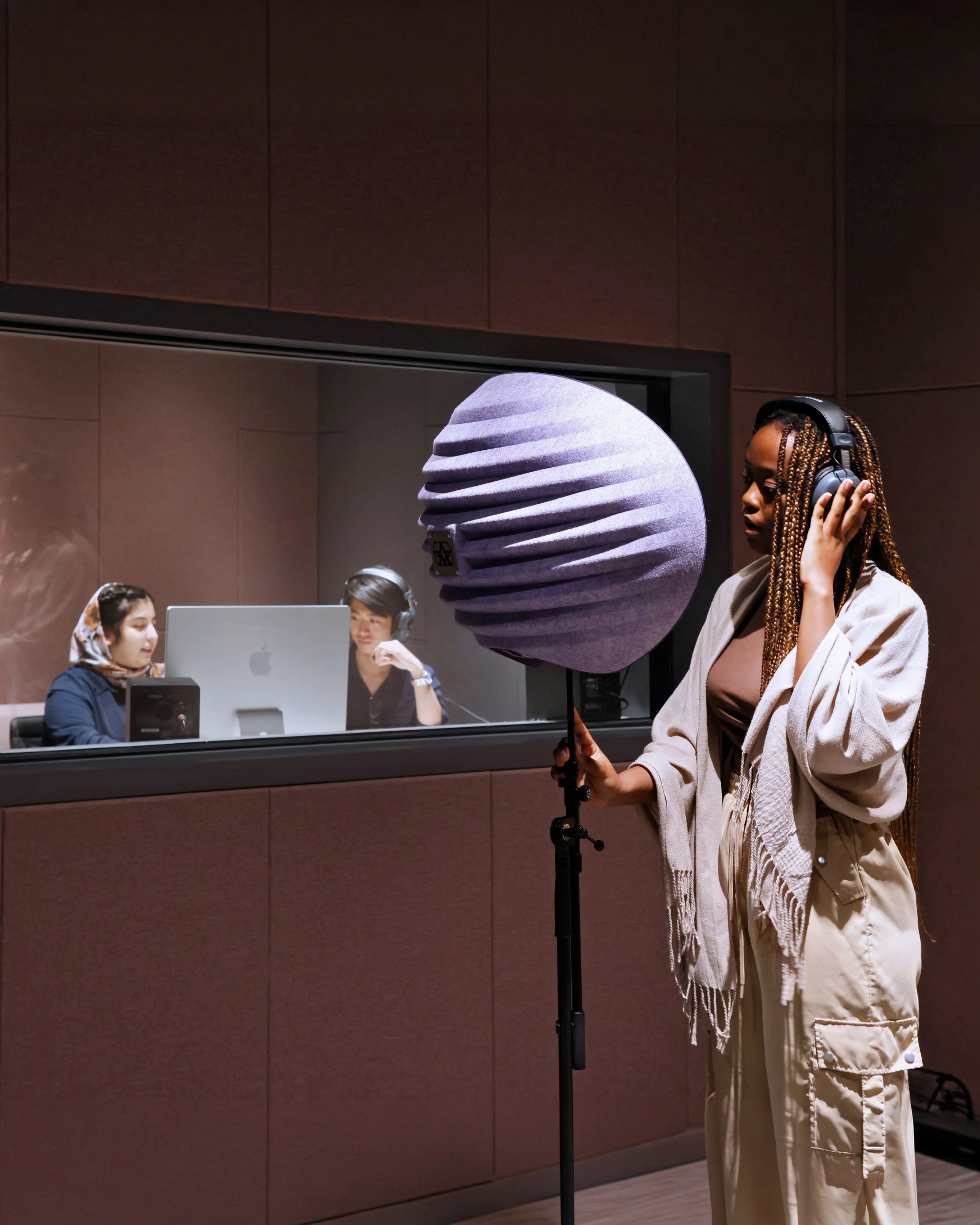 Sinh viên BUV thu âm bằng micro và tai nghe trong phòng studio âm thanh hiện đại.