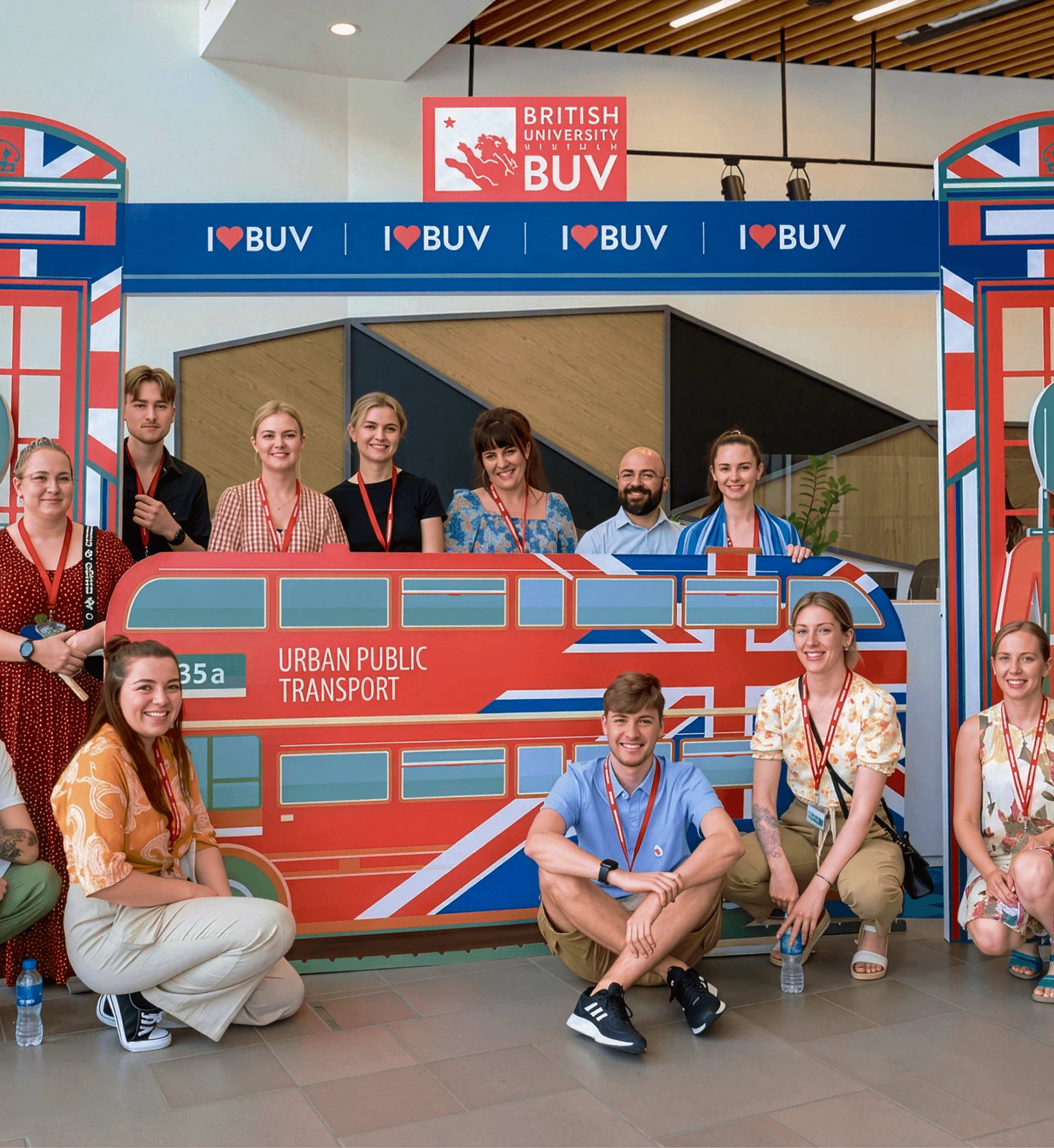 Sinh viên và nhân viên British University Vietnam (BUV) chụp ảnh bên mô hình xe buýt Anh Quốc “I ♥ BUV”